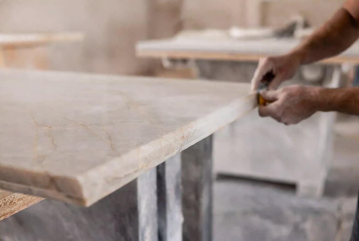 Hands working on a stone edge in the Quiroz shop
